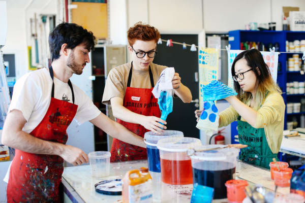 Three students working on art project