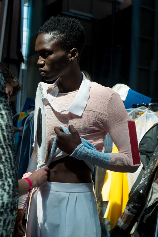 A model wearing a pink and blue knitted top and trousers 
