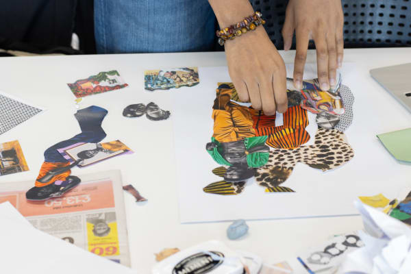 Close shot of hands placing magazine clipping in collage composition