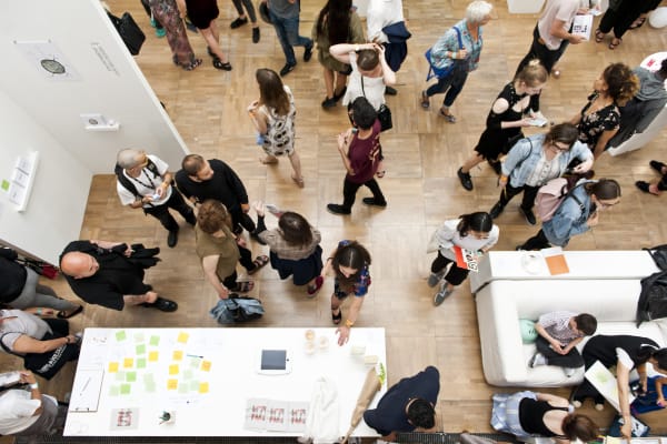 A bird-eye-view of a crowd of people gathered within a gallery space at LCC.