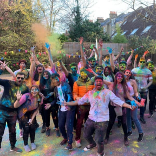 a group of students covered in paint pose for the camera