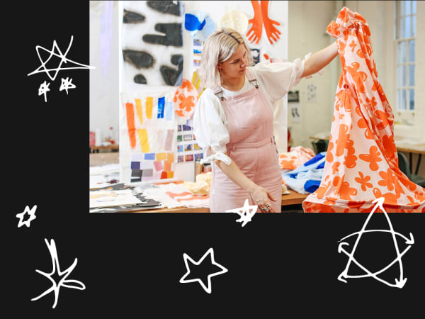 person in a studio holding up some patterned fabric