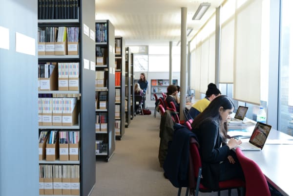 People sitting and working in a library