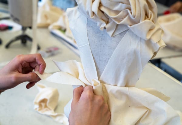 Students fitting garment on toile