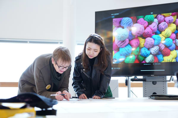 Tutor and student looking at material on a desk