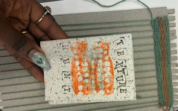 A hand holding a print that says: 'texture hunt'