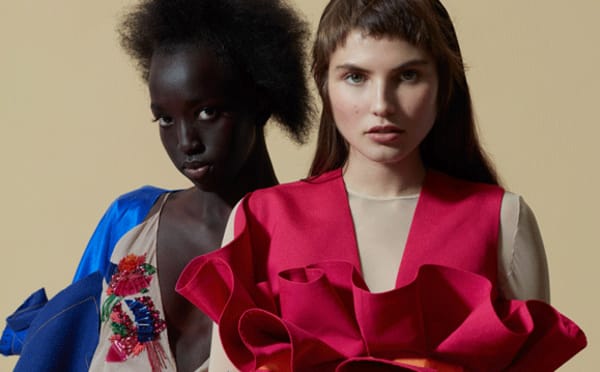 Two female models wearing MA Fashion Design Technology Womenswear 2018 clothing against a putty coloured background.