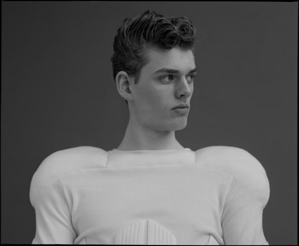 Male model in white top with padded shoulders. Black and white photography
