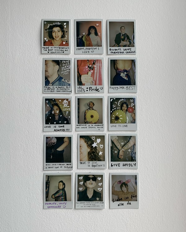 Polaroid photographs displayed in grid on wall with hand-written messages