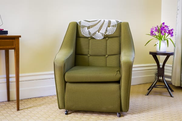 Photograph of a green leather chair in an interior.