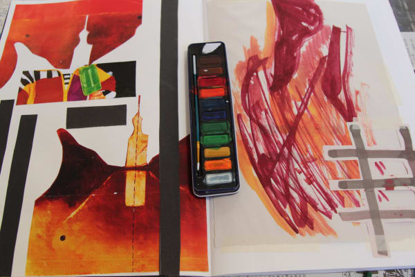 Collage and mark marking in orange and red hues with paint palette central to image