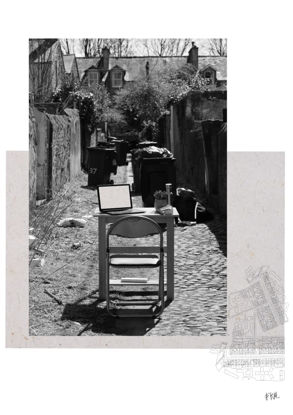 Empty desk with laptop set up in alleyway