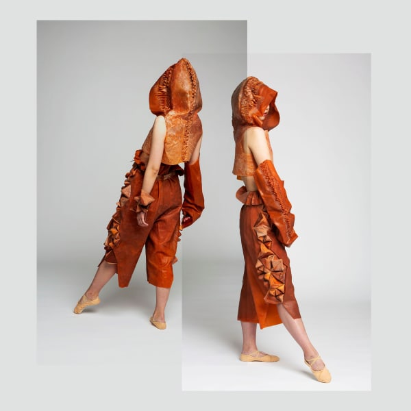 Figures in space wearing orange material garments