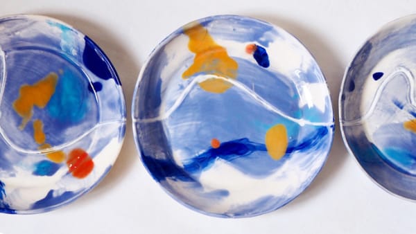 3 ceramic plates painted blue, white, with highlights of orange and red