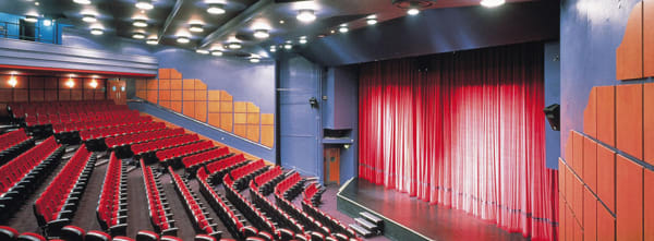 Rows of red chairs face a large stage
