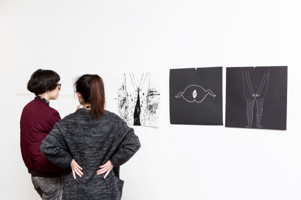 Two women discussing student artwork