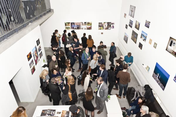 Crowd of people in a gallery viewing a photography exhibition