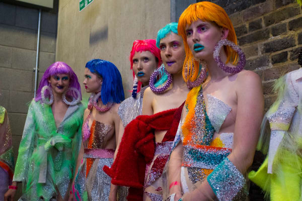 Models wearing coloured wigs and sparkly garments