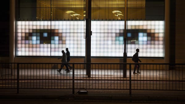 Giant digital screen with human eyes with pedestrians walking past.