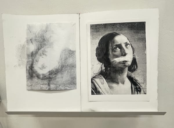 A photo of a mixed-media or print-based artwork mounted on a wall. It consists of two monochromatic (black and white) printed or transferred images on textured paper displayed side-by-side.  Left Panel:  The image is abstract and appears to be an upside-down face, faint and ghostly, almost like a rubbed or transferred image.  There are additional textures and patterns visible, including what looks like an ornamental or lace-like detail on the left side.