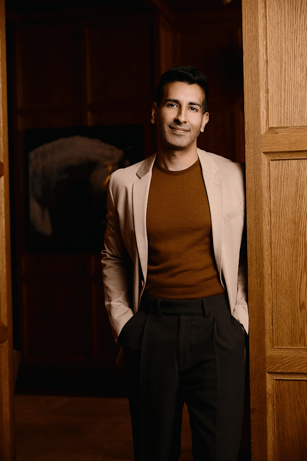 Man in suit leaning against wall