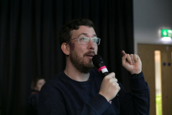 A person holding a microphone and speaking