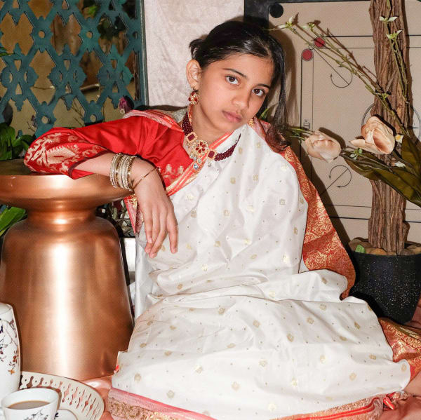 A child wearing a sari looking into the camera