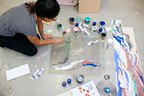 Student painting on the floor in Art studio