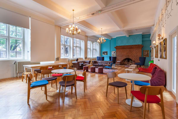 Interior shot of spacious modern lounge area. There are a variety of sofas, chairs and tables in different colours and fabrics.