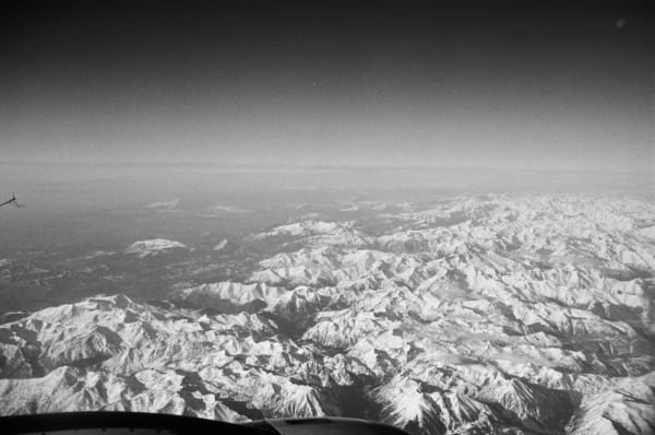 A view of mountains in black and white from the seat of an airplane