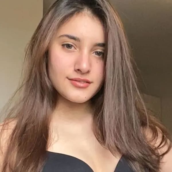 Headshot image of Indian UAL student, Anisha Kohli wearing a black vest whilst stood in a room.