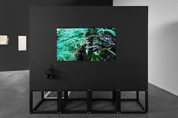 View of an exhibition video installation screen and headphones