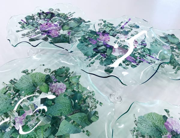 Images of a garden printed onto glass sculptures