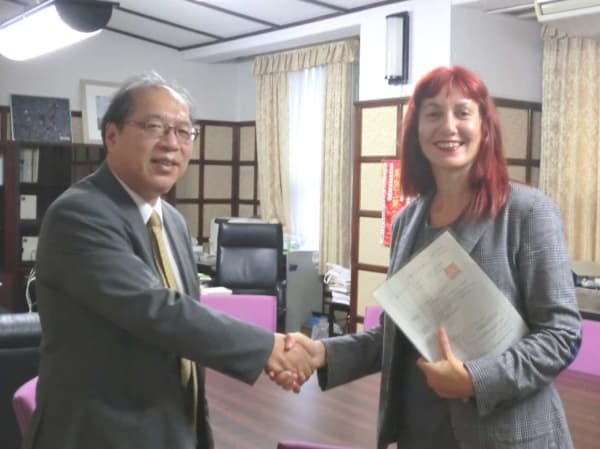 Two people shaking hands and smiling