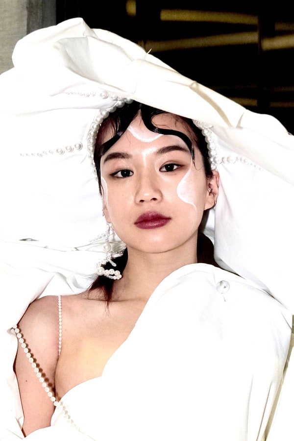 Portrait of person in large white hate with dress