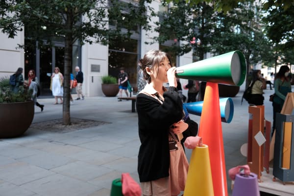 Woman speaking through a mega phone which was part of an exhibit for the Google project