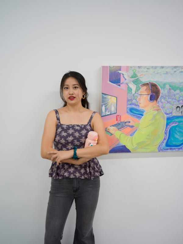 Xinan Yang stood with one of her paintings