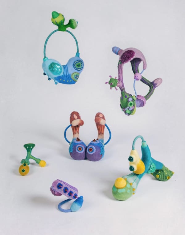 a group of several tiny colourful clay sculptures witth a fashion theme