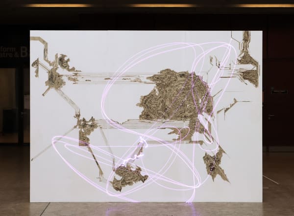 A large white screen or board with brown textured clusters representing a mapping of territories. A soft pink squiggly line is overlaid throughout