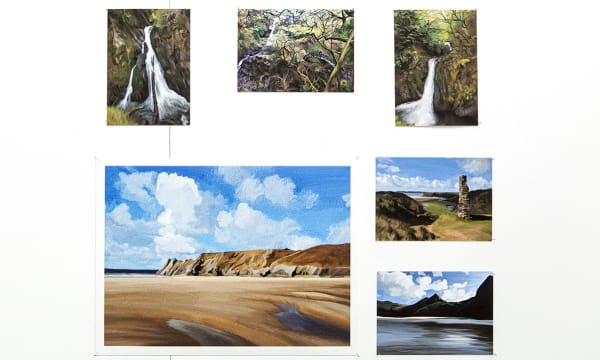 Student paintings of cliffs and waterfalls.