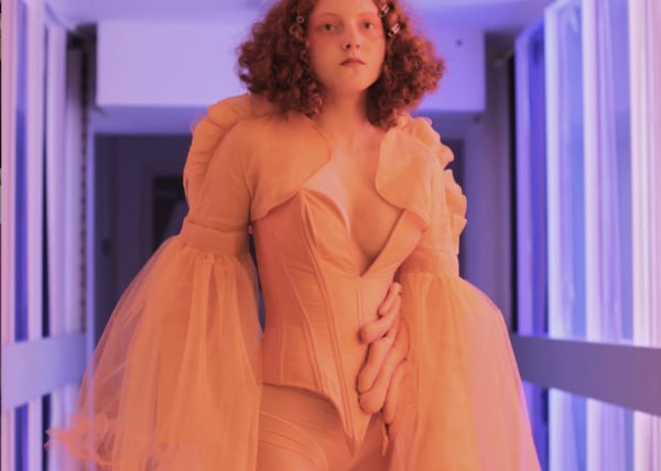 Red-haired model in orange dress with corset and tulle detail.