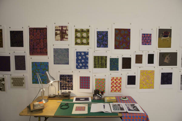 A number of wall artworks and a desk