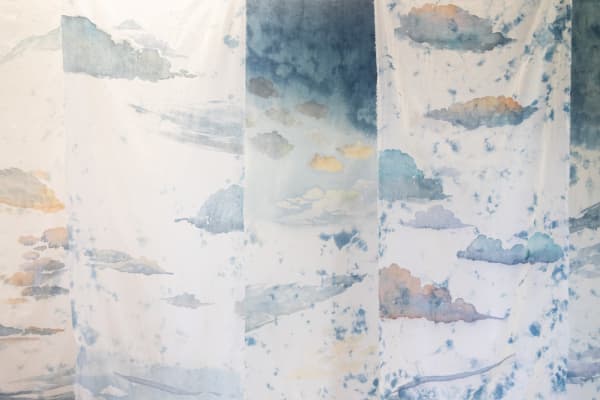 Close up of pale white textile with faded blue cloud design