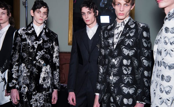 Five dark-haired male models in luxury suits.