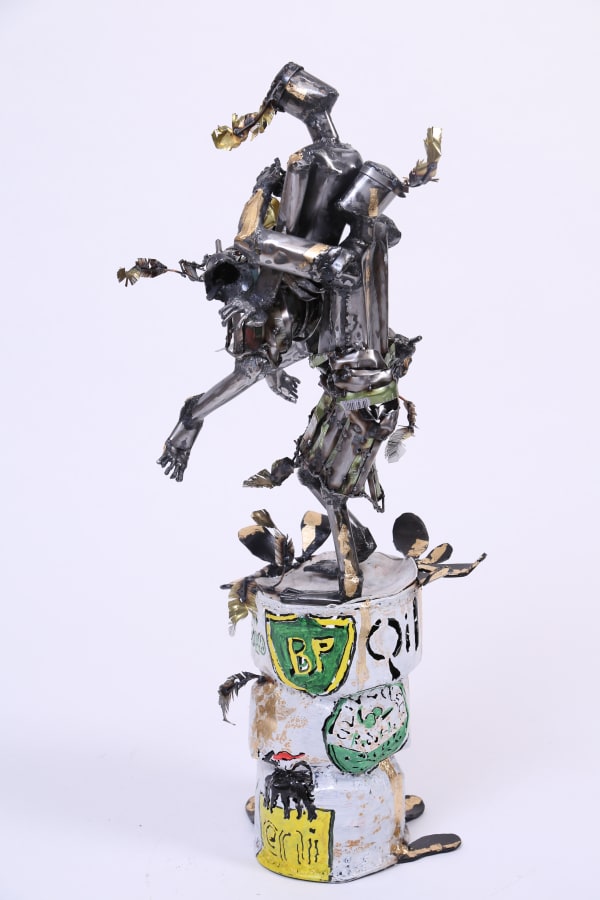 Sculpture of two people dancing on top of a can - the people are made out of metal and are abstractly formed