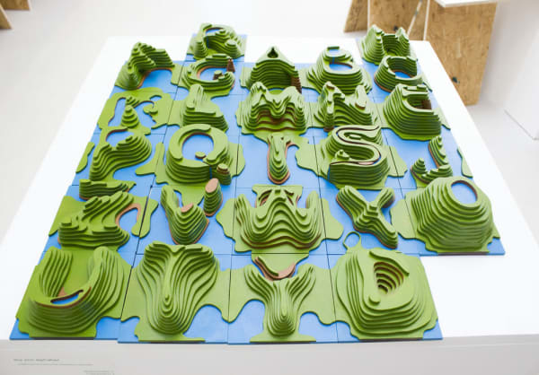 an alphabet built up as a 3D model of contour lines and looking like landmasses. Letters in bright green on a blue background
