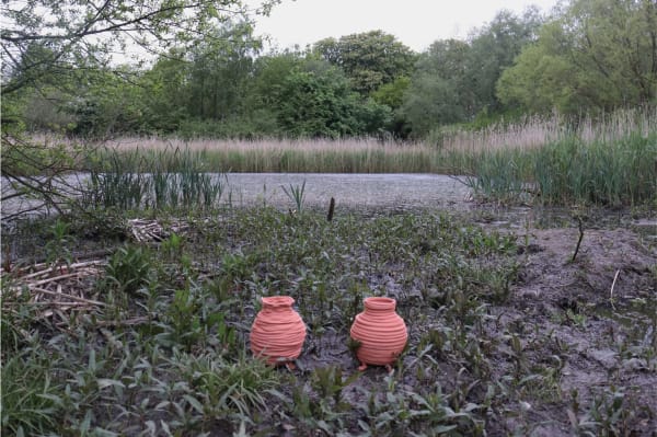 Two clay pots by a river