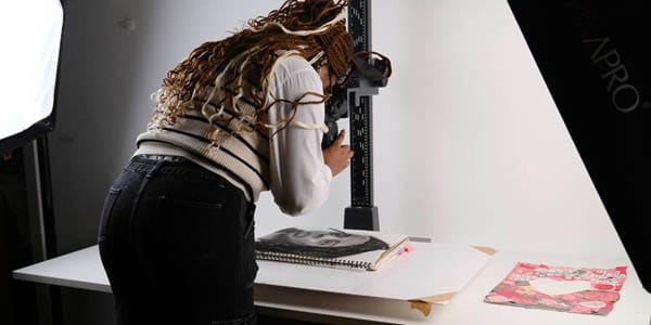 A students takes a photo of her work in a professional photography studio