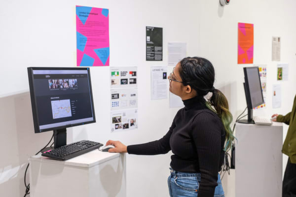 Student engaging with a piece of digital work in an exhibition at LCC.