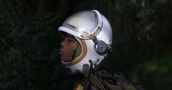 A side profile photo of a young boy wearing a helmet